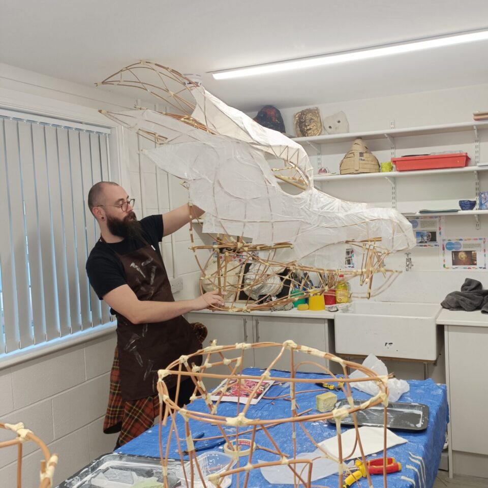 A large dragon puppet being constructed